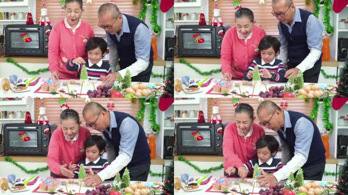 亚洲男孩和祖父母一起制作和装饰圣诞树蛋糕，为圣诞晚会做准备。一家人一起在装饰有装饰品的厨房里度过快乐