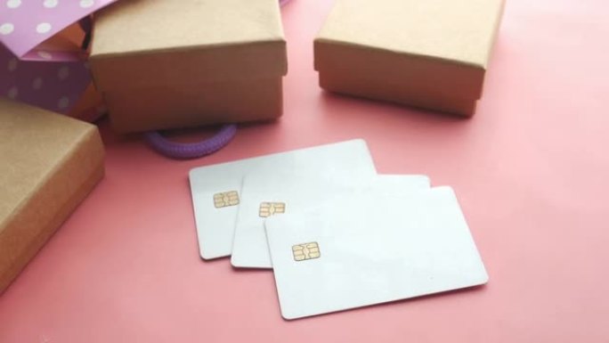 粉红色背景上的信用卡和礼品盒