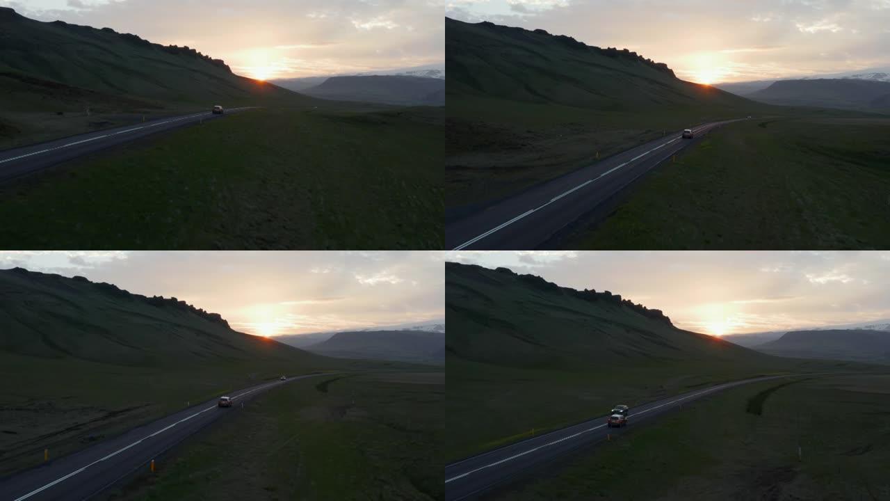 日落时在北欧乡村公路上行驶的汽车的前瞻性跟踪。风景如画的风景。冰岛