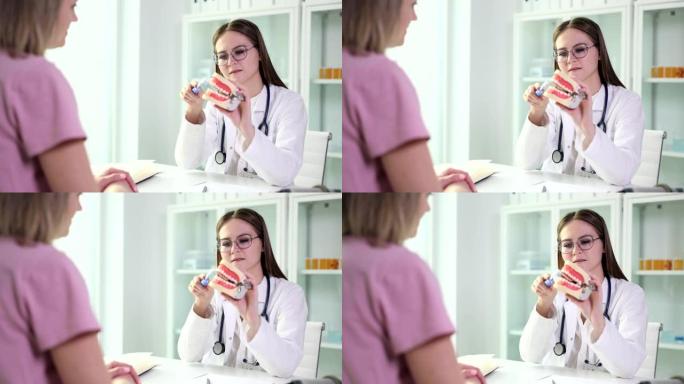 牙医医生展示如何正确刷牙的女性患者的牙齿植入物