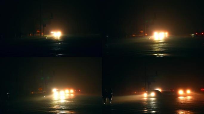在停电时，大灯明亮的汽车在黑暗的道路上驶近。能源危机导致停电。