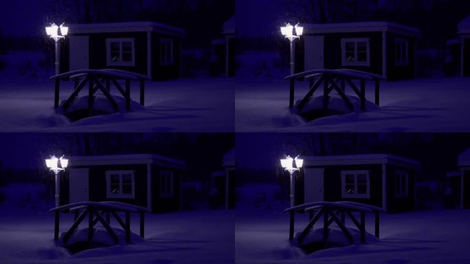 晚上大雪下的白色旧街灯，三重头，小木桥和乡村小屋-一切都被软雪覆盖，冬季童话