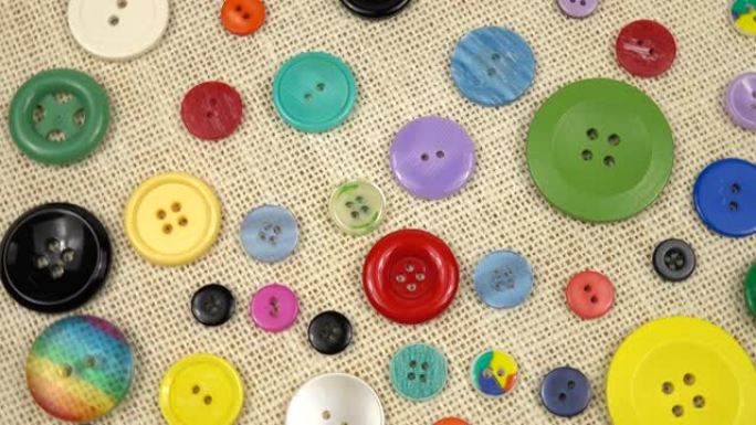 纺织品背景上的一组彩色塑料纽扣