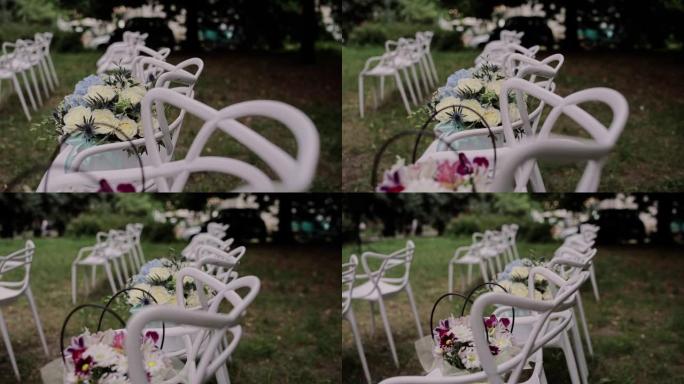 公园内婚礼仪式拱门附近的白色椅子