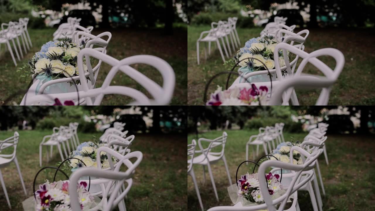 公园内婚礼仪式拱门附近的白色椅子
