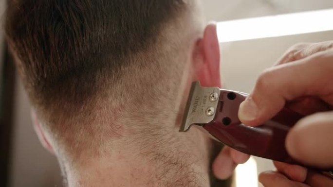 帅哥用电动修剪器换新发型。用修剪器关闭。