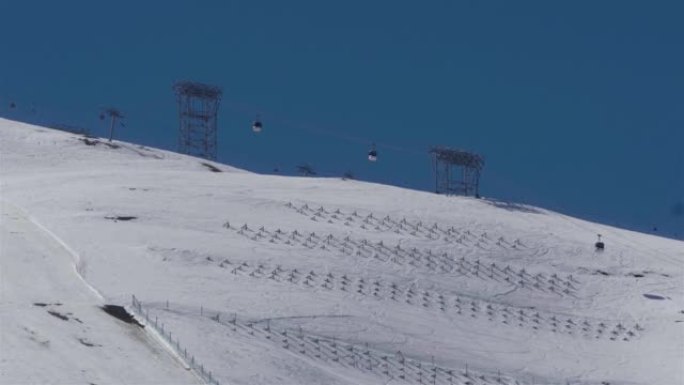 爬过积雪覆盖的山坡的缆车安装了防止雪崩的系统