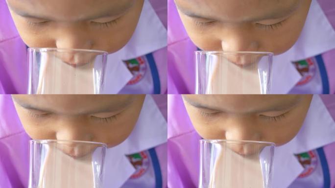 亚洲男孩喝玻璃牛奶。