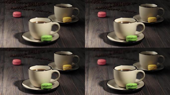 咖啡豆成分。木桌背景装饰有咖啡豆、彩色杏仁饼和咖啡杯。焦点从背景转移到前景。4K