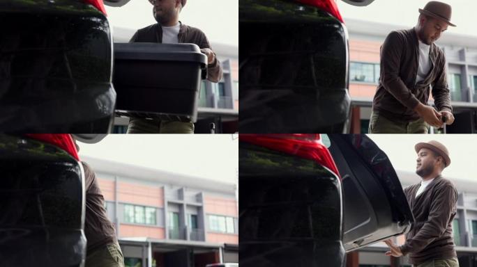 一名年轻的亚洲男子将行李箱放在汽车后部，准备离开。打开汽车后部放行李到其他省份旅行。