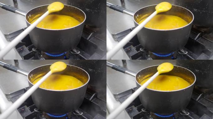 在充满蒸汽的工业厨房中烹饪南瓜飞溅奶油汤