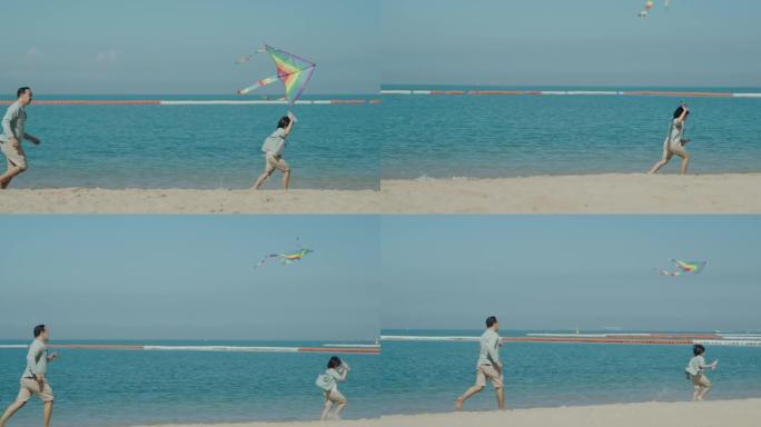 亚洲父亲带着风筝和儿子在沙滩上奔跑。