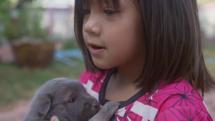 可爱的女孩和她的小狗玩。