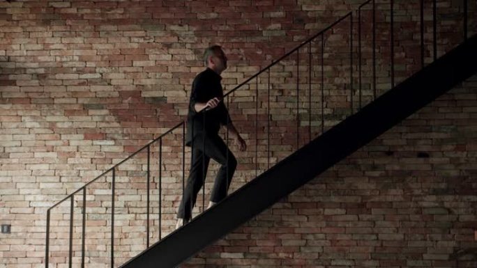该名男子正在房屋中爬楼梯到房屋的二楼。
