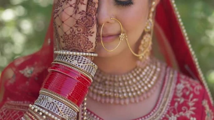 一位幸福的印度新娘用手遮住脸的肖像，手在印地语上
