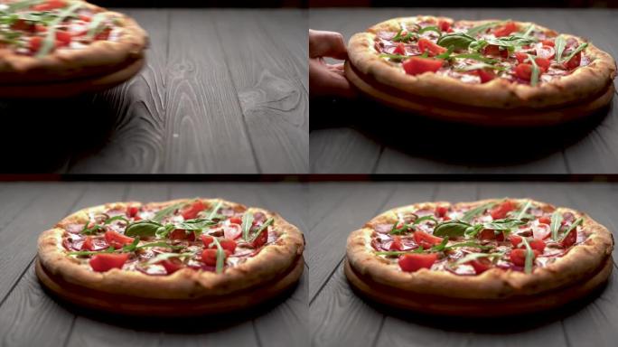 热披萨，配有意大利腊肠、罗勒和马苏里拉奶酪和西红柿，背景为深色木质。乡村木桌上的披萨