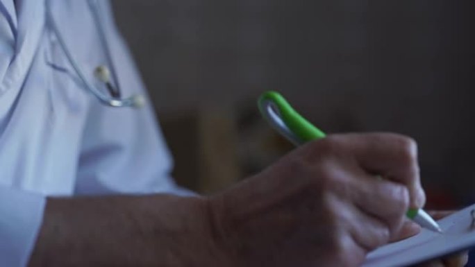 成熟的医生，用皱纹的钢笔在剪贴板的纸上写字。