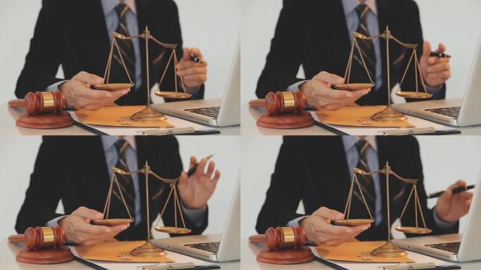 正义与法律概念。法庭上的男法官带着木槌，与计算机和对接键盘，眼镜一起工作，在晨光下的桌子上
