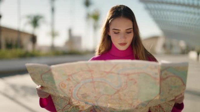 年轻的金发女子在街上迷失了城市地图