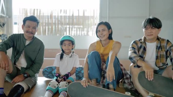 快乐的多代家庭滑板生活方式，假肢父亲的肖像，戴着安全绿色蓝色帽子的女儿，穿着黄色现代布的母亲和带着孩