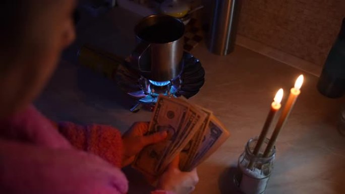 这个女孩在烛光下数钱。乌克兰断电