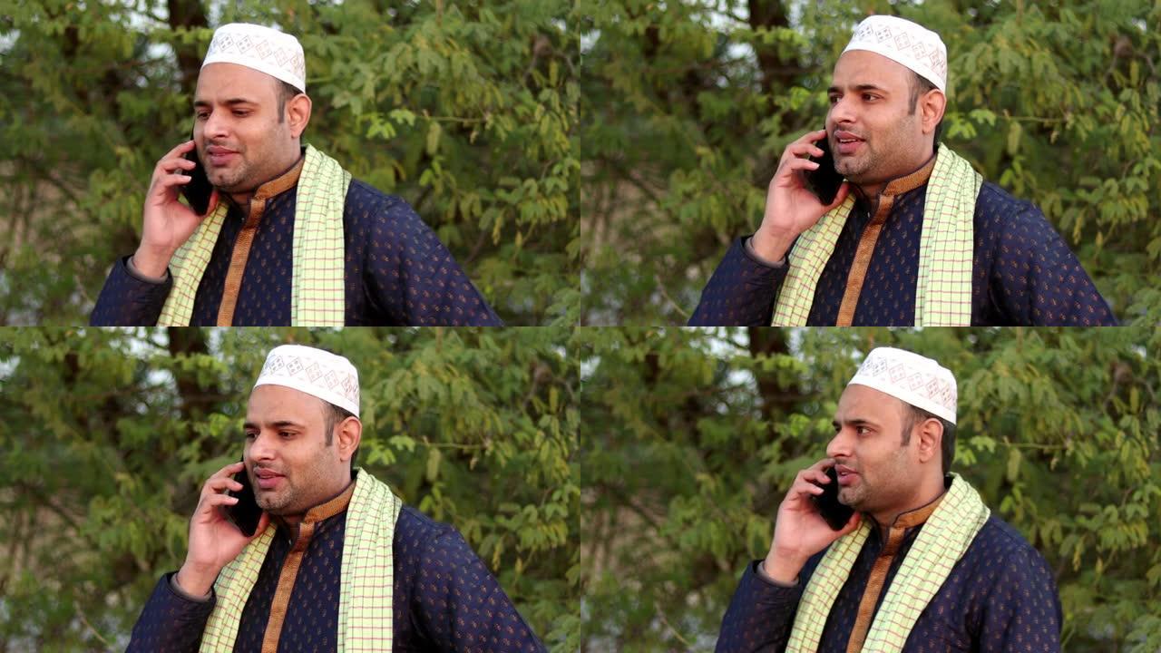 年轻的印度穆斯林男子在户外用手机聊天