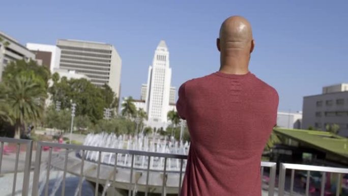 混合种族男子在洛杉矶市政厅的喷泉4K
