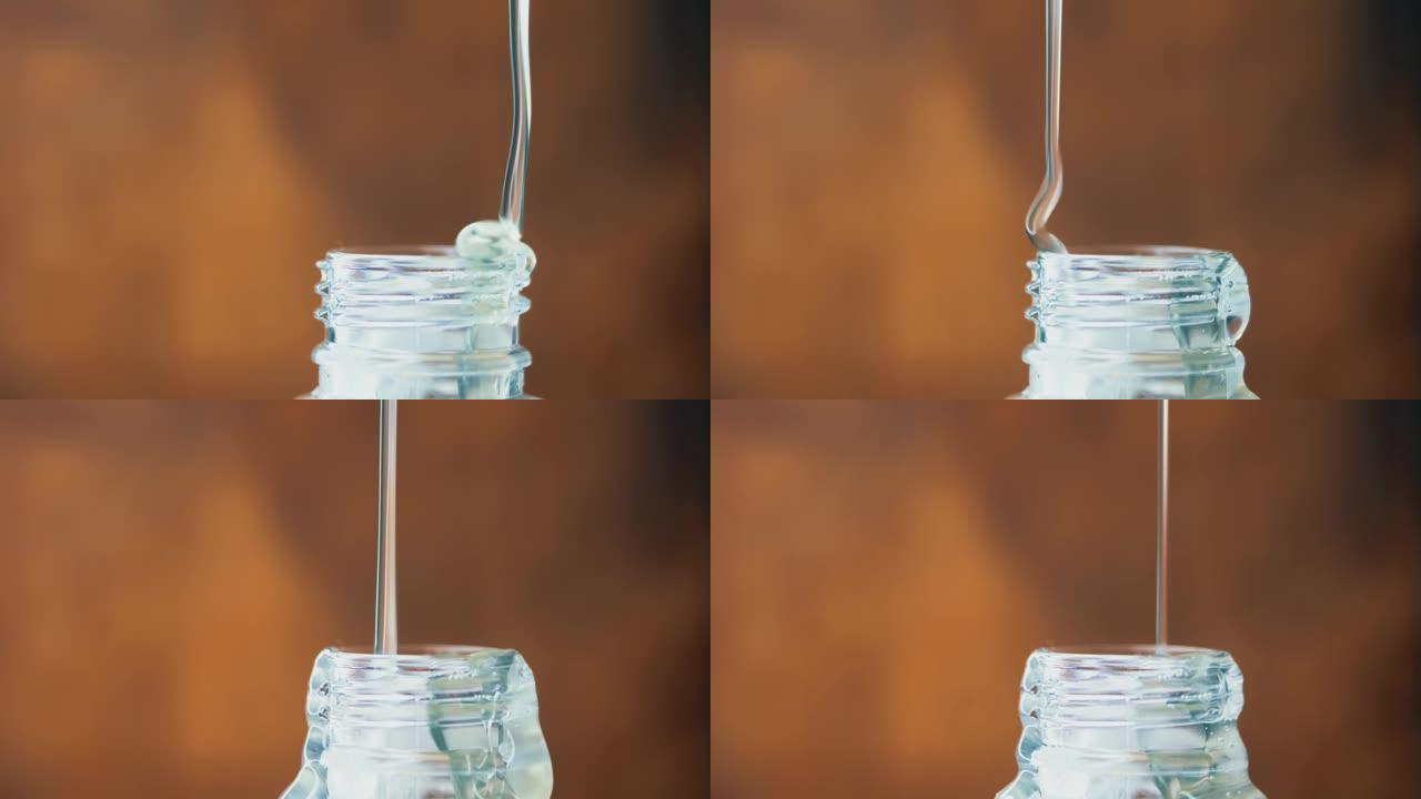 厚厚的透明液体缓慢倒入细流中。塑料瓶颈。糖浆