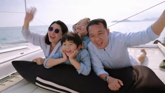 一个亚洲家庭在家庭度假，家庭关系期间在游艇上玩得开心