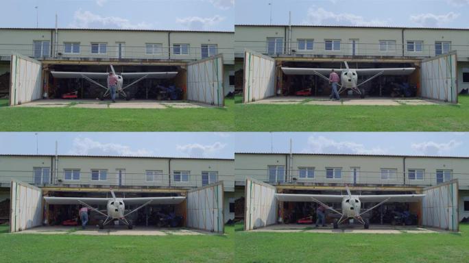 飞行员在乡村机场的维修机库内固定飞机螺旋桨。