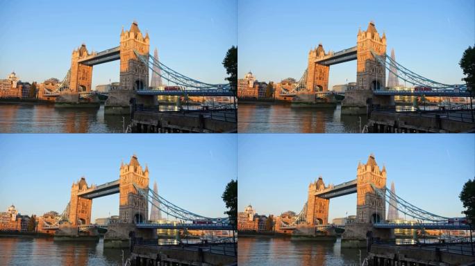 伦敦塔桥被清晨的阳光照亮。一辆红色的伦敦巴士停在桥上。Version 7