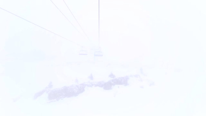 钢缆上的六人升降椅在云中移动。滑雪胜地有雾的天气。