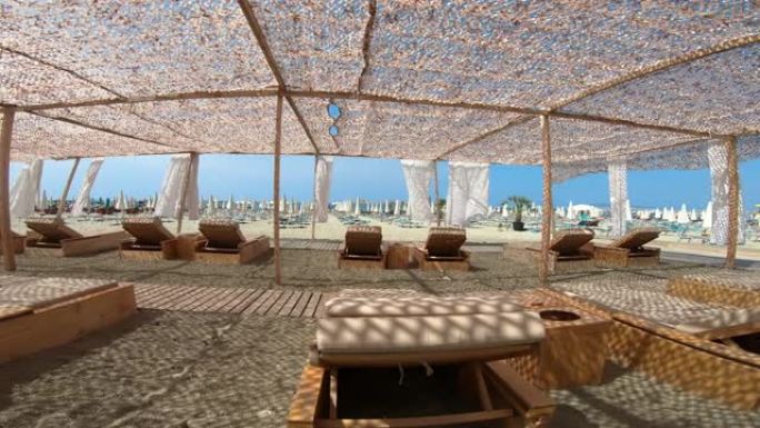 避暑海滩度假村，在防晒网影下配有豪华躺椅
