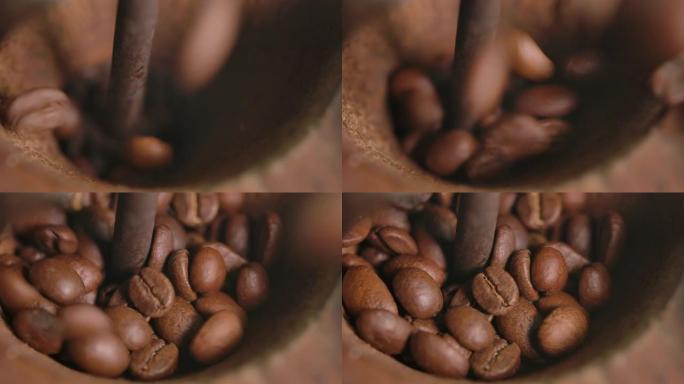烤咖啡豆落入复古青铜咖啡研磨机的特写镜头