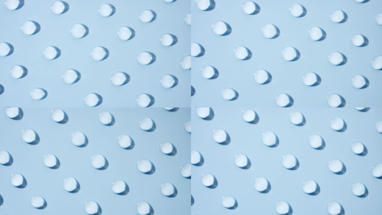 淡蓝色背景上移动透明水滴的俯视图
