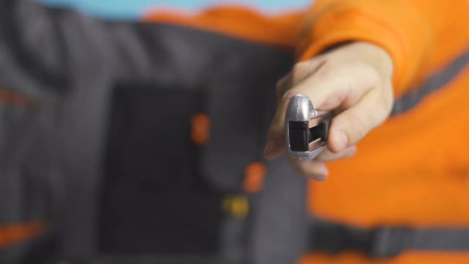 橙色衬衫和工作服手拿美工刀的修理工垂直视频
