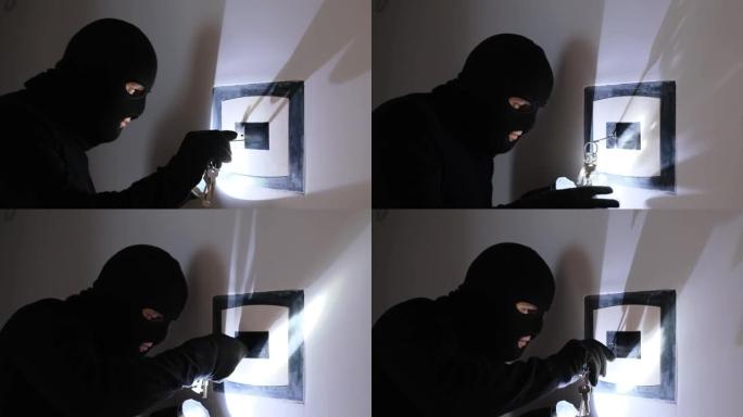 一个戴着黑色面具的人闯入银行保险库并打开保险箱。强盗从保险箱里偷钱。