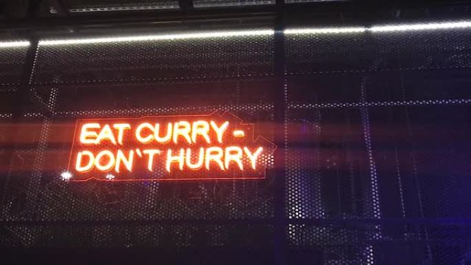 霓虹灯题字吃咖喱不要着急，印度菜。
