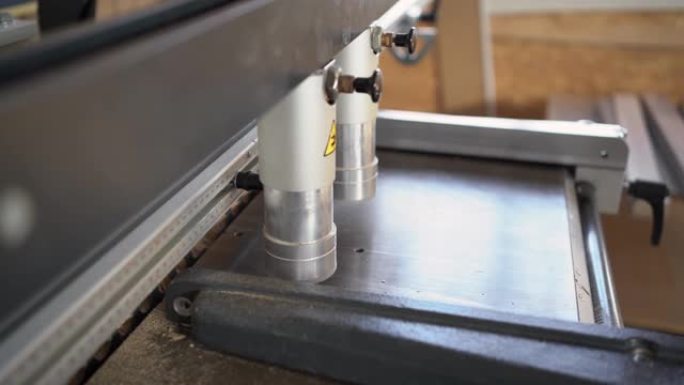 钻孔机的特写在木板或刨花板上打孔。工厂和木工行业中木制家具的生产和制造过程