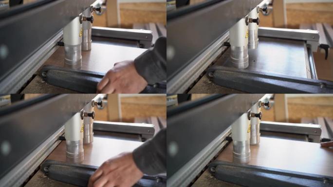 钻孔机的特写在木板或刨花板上打孔。工厂和木工行业中木制家具的生产和制造过程