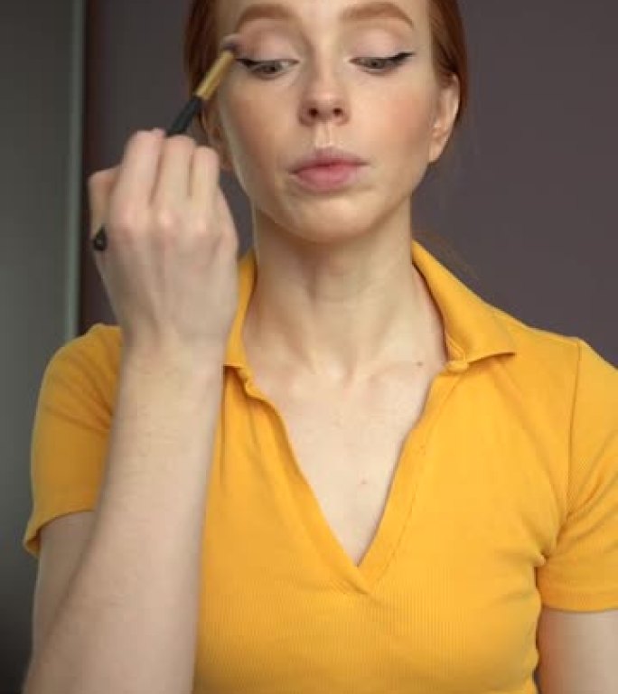 在线直播中，迷人的女性化妆师做眼妆的垂直视点看着相机与观众交谈。