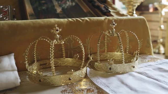 桌子上躺着两个牧师的金冠。在宗教对象附近射击