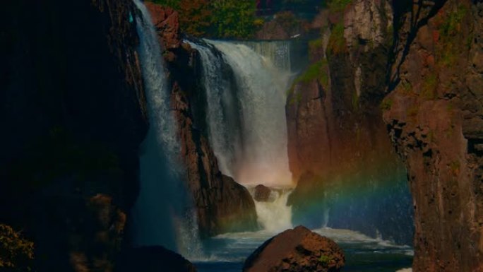 宏伟的彩虹出现在巨大的自然瀑布前