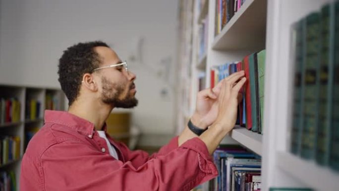 大学图书馆校园里的非洲研究生在书架上看书，寻找书