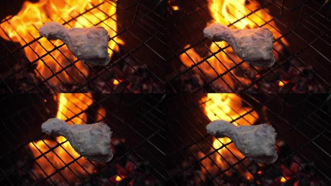特写，慢动作。鸡肉躺在煤的烤架上。一团美丽的火焰在肉下猛烈地燃烧起来。大火高高地覆盖了鸡肉。