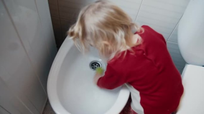 可爱的女婴在浴室清洁坐浴盆帮助她的母亲