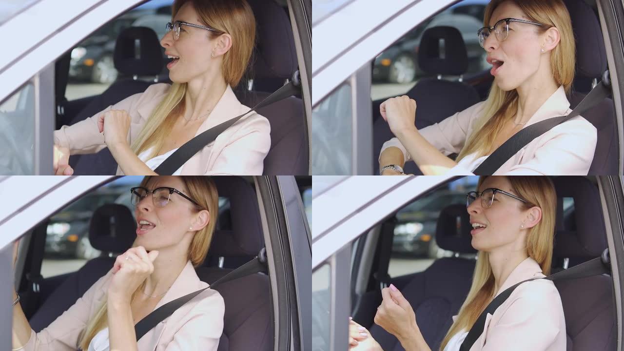 积极兴奋的女人在车里坐在驾驶座上跳舞，心情愉快
