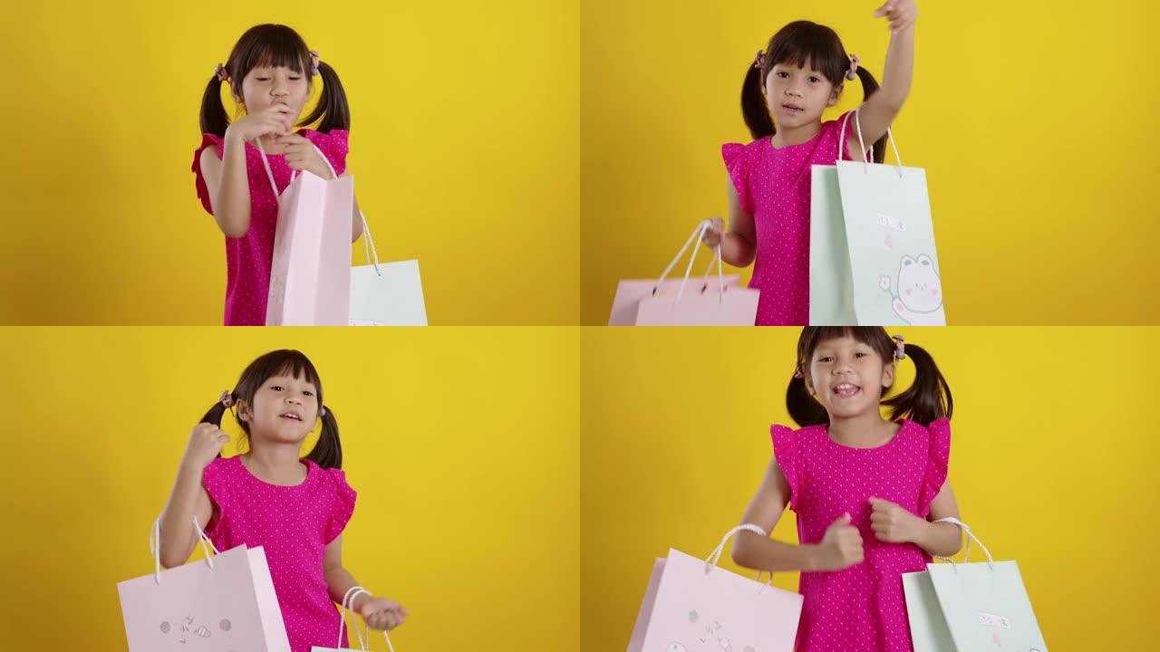 黄色背景上拿着购物袋的小女孩。