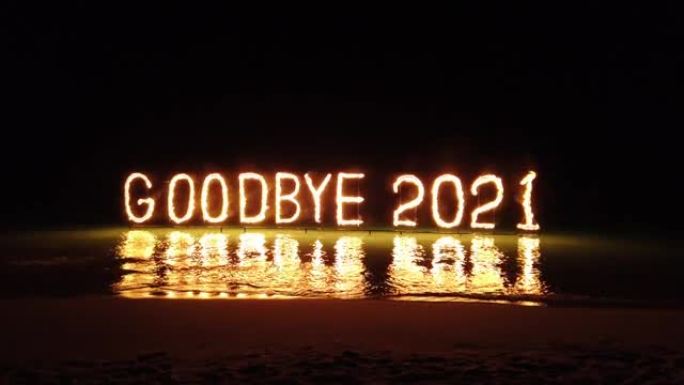 在热带海滩上燃烧刻字，庆祝2021年的最后一天。
