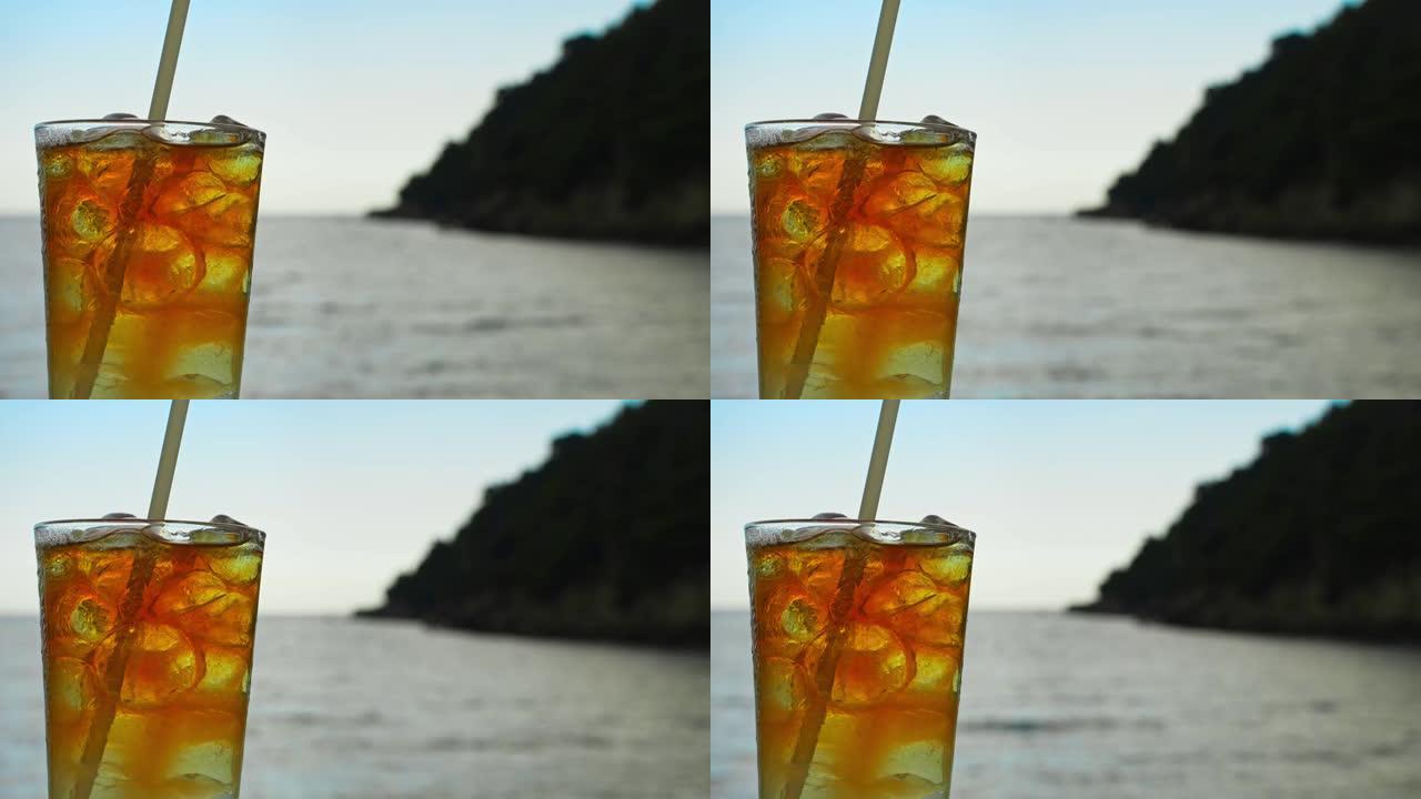 一杯麦太鸡尾酒在大海背景前。